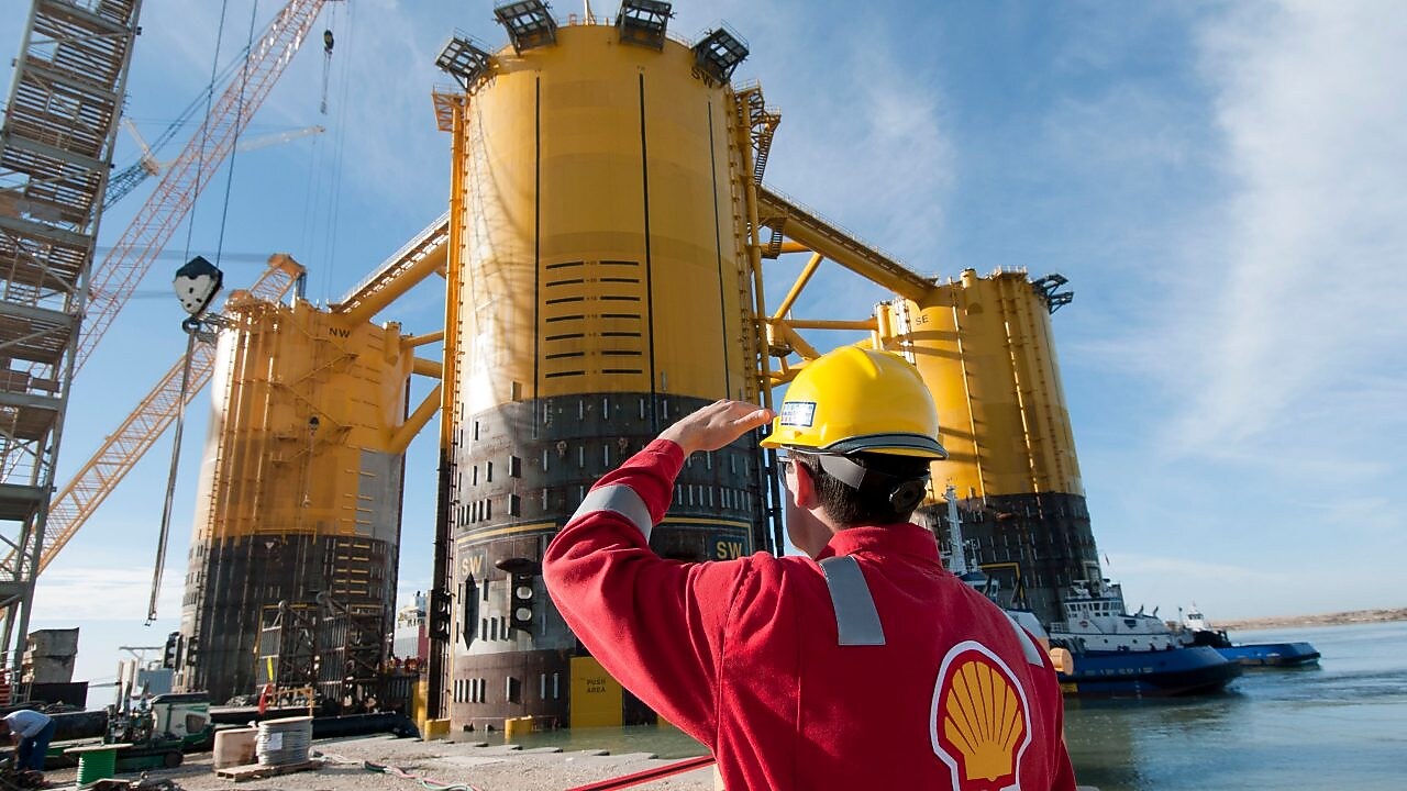 Рабочие переправляются на новую платформу, построенную рядом с существующим глубоководным проектом «Малампая»