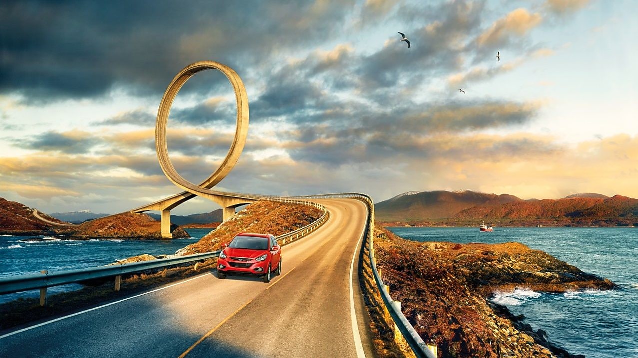 Красный автомобиль на дороге у реки