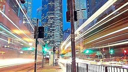 A city scape at night with trailing lights from cars going by.