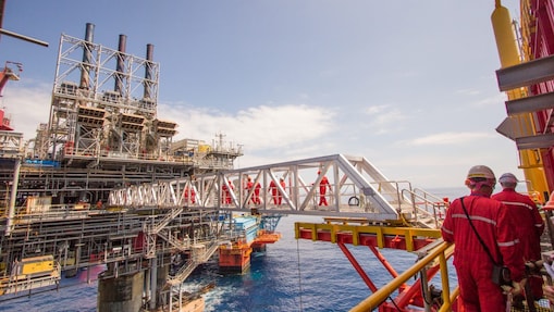 Рабочие переправляются на новую платформу, построенную рядом с существующим глубоководным проектом «Малампая»