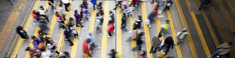 Пешеходы переходят оживленную улицу в Гонконге
