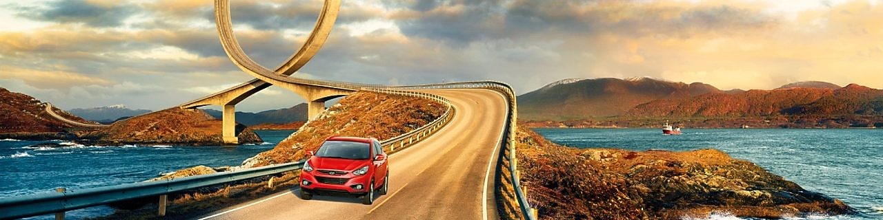 Красный автомобиль на дороге у реки