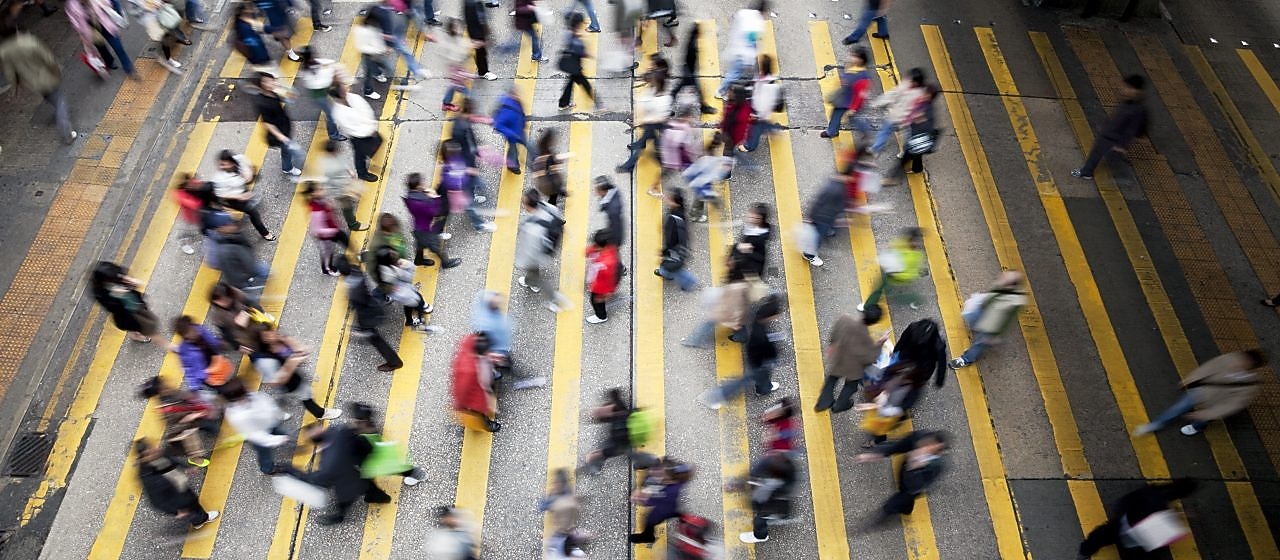 alt="Пешеходы переходят оживленную улицу в Гонконге"