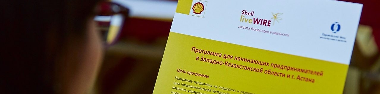 Тренинг қатысушысы Shell LiveWIRE брошюрасына қарауда