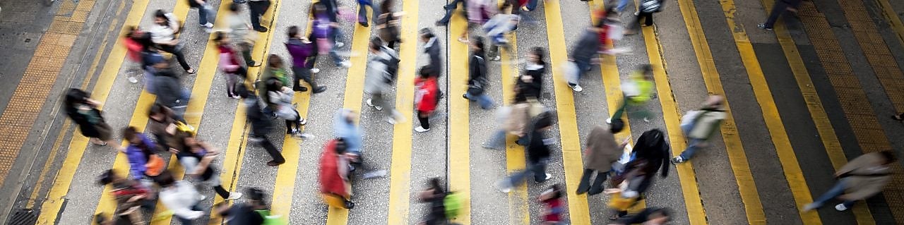 Пешеходы переходят оживленную улицу в Гонконге