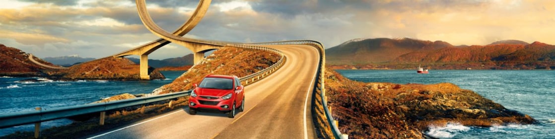 Красный автомобиль на дороге у реки