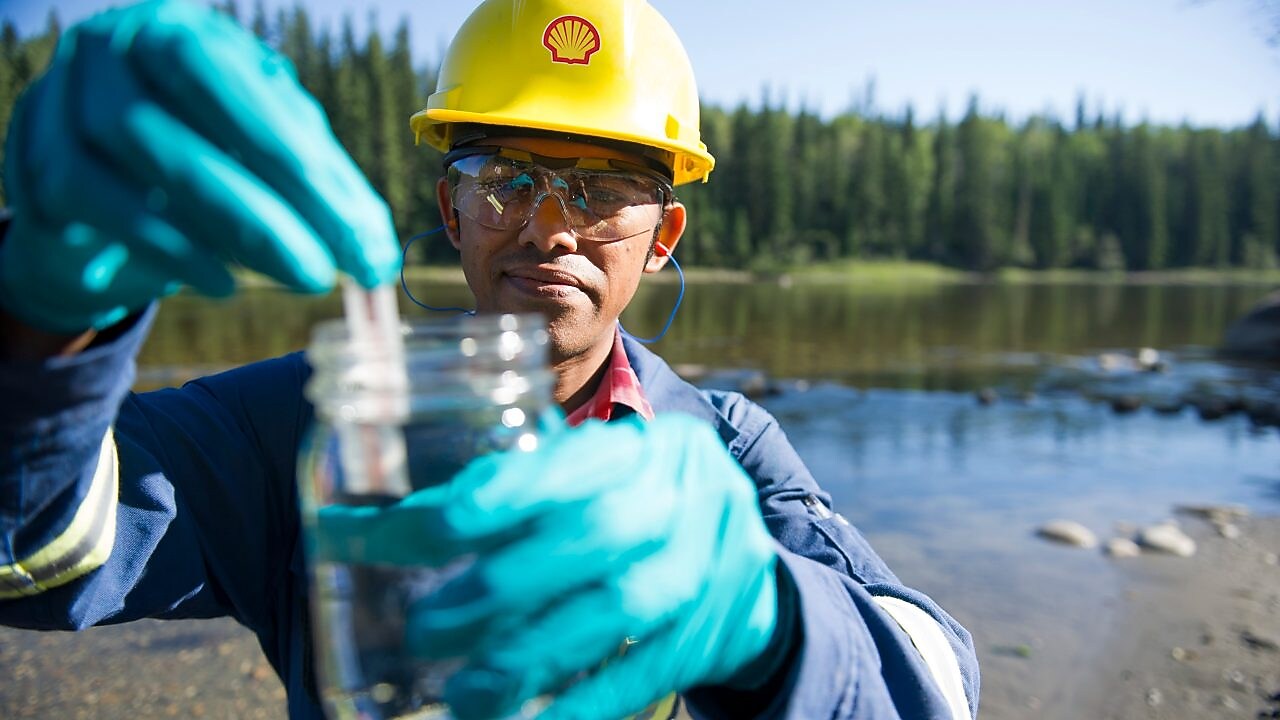 Координатор-эколог концерна «Шелл» берет пробу воды